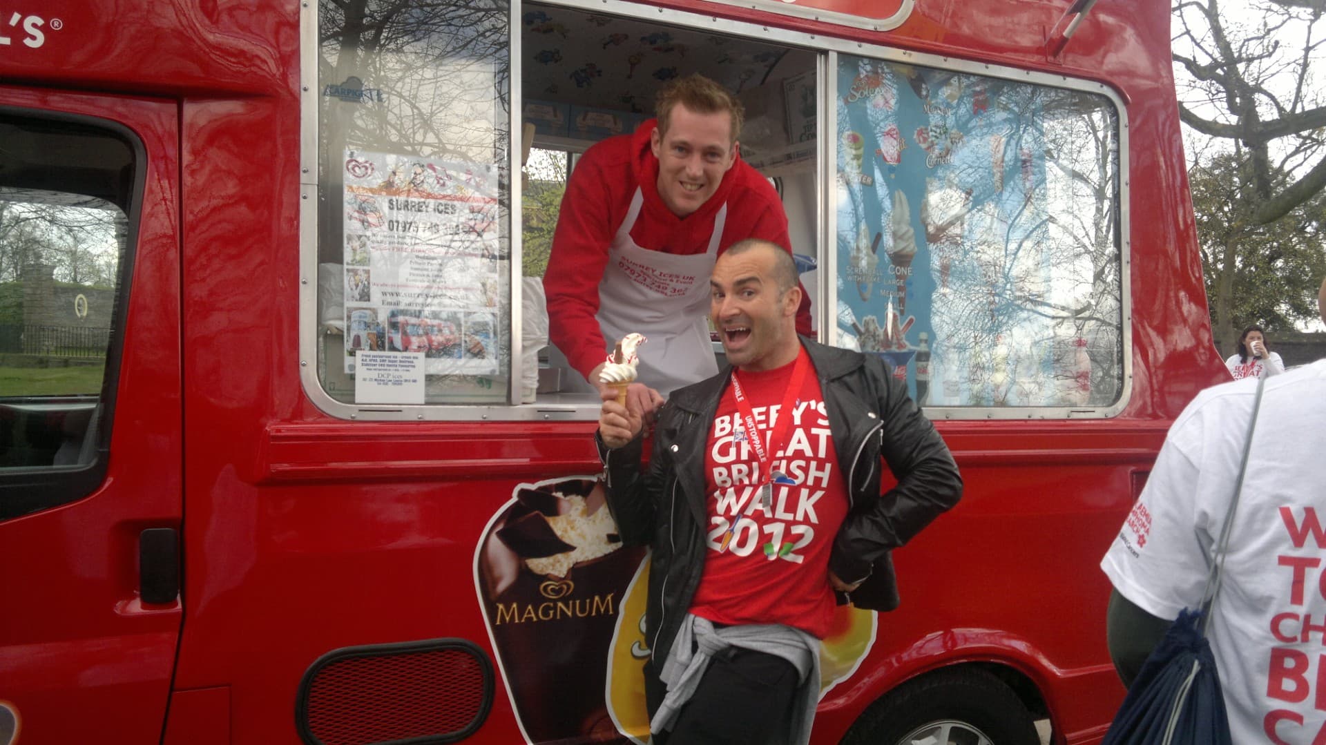 A man in a red Surrey Ices hoodie serving from a red van while a walker holds a cone during Beefy's Great British Walk 2012